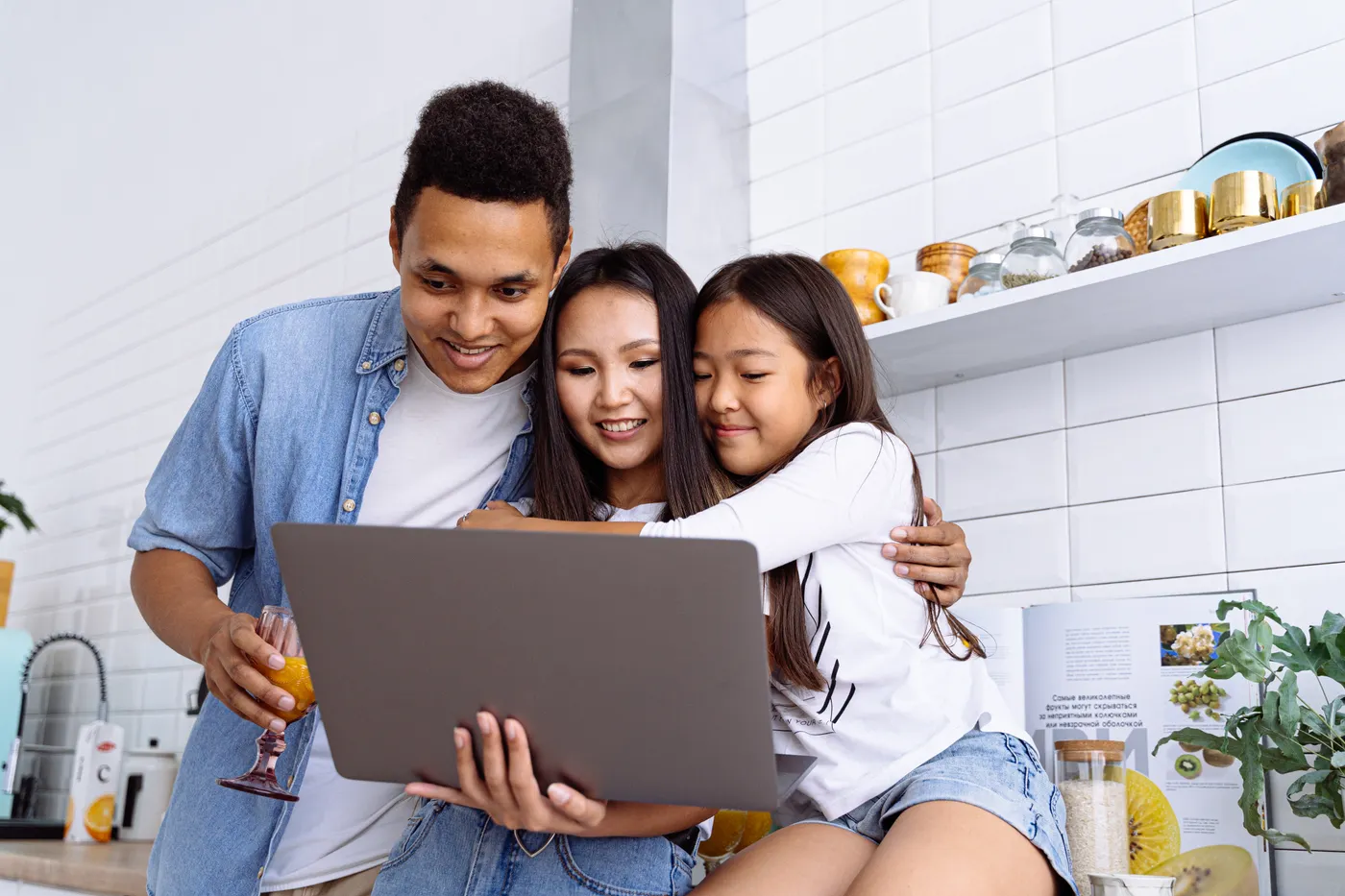 A child with her mum and dad looking at a laptop together at home